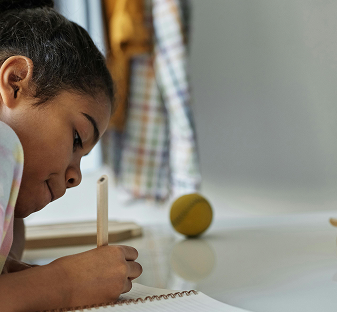 a child sitting at a table writing