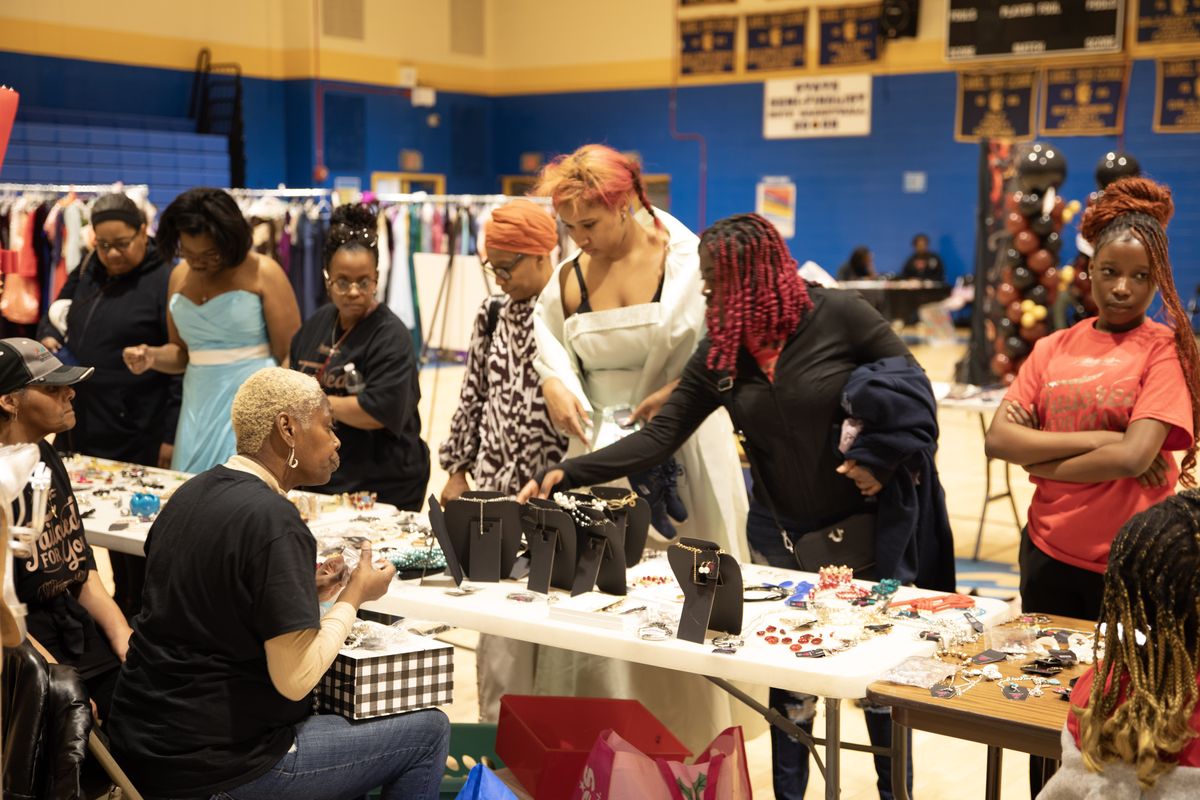 Students and volunteers choosing jewelry at a Prom Boutique accessories table